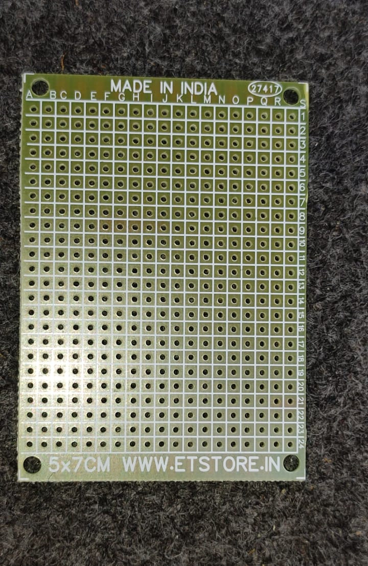 Green perforated breadboard with 'Made in India' label on a dark textured background